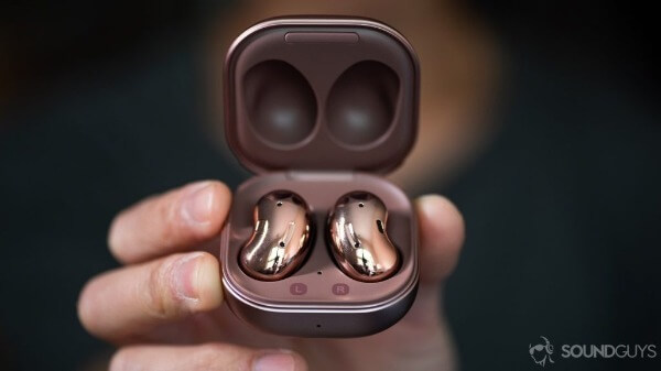 Egy férfi a keében tartja a Samsung Galaxy Buds Live bluetooth fülhallgatót.