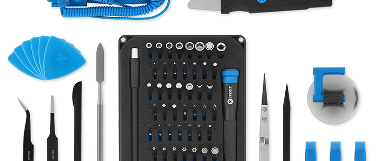 Egy okostelefon javításához szükséges szerszámkészlet egy fehér asztalon.