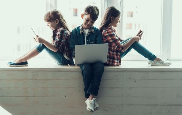 Gyerekek laptoppal és telefonokkal