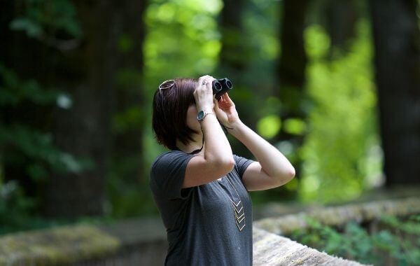Egy nő távcsővel keres valamit