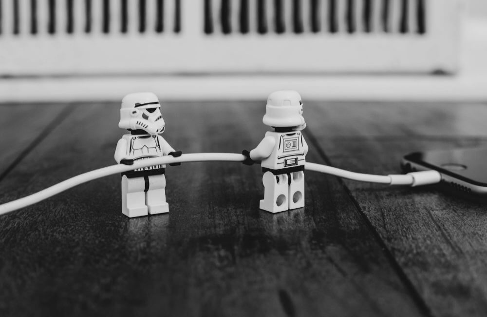 Két LEGO figura tart egy töltőkábelt