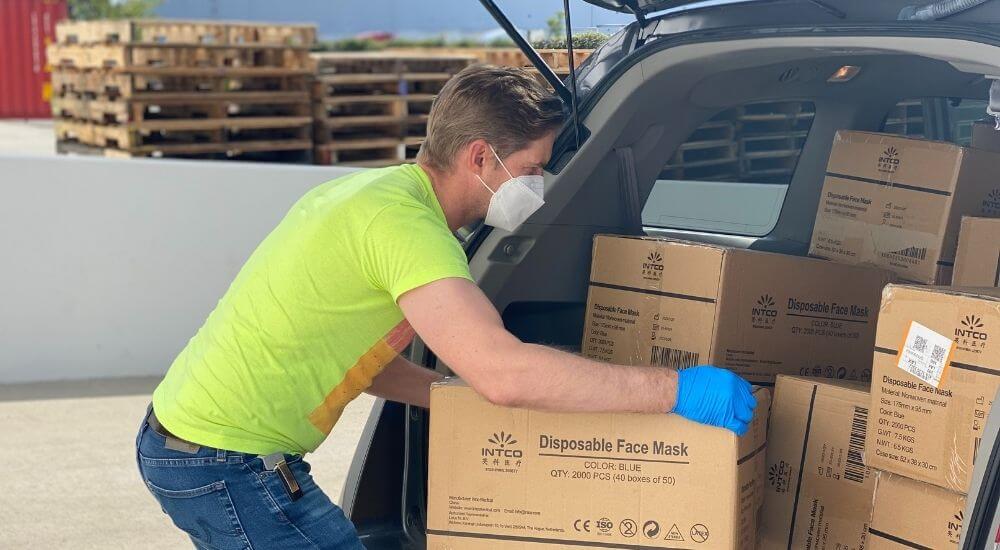 Egy férfi dobozokat pakol egy autóba