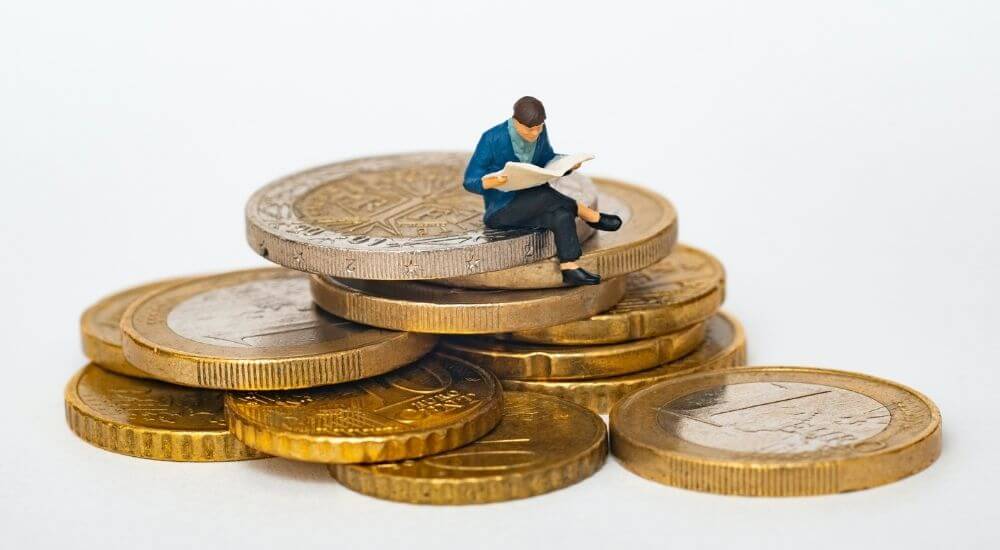 Egy figura ül egy rakás pénzen